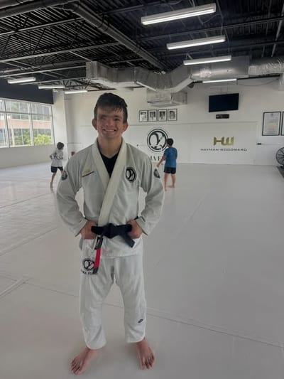 Carlos Alvarez standing on the mats in a white gi with a black belt