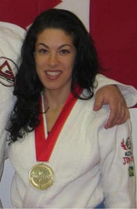 Rima Avellan in a white gi with a gold medal around her neck